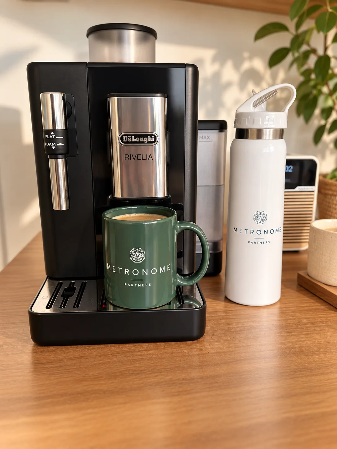 Un mug et une gourde Metronome Partners posés près de la machine à café